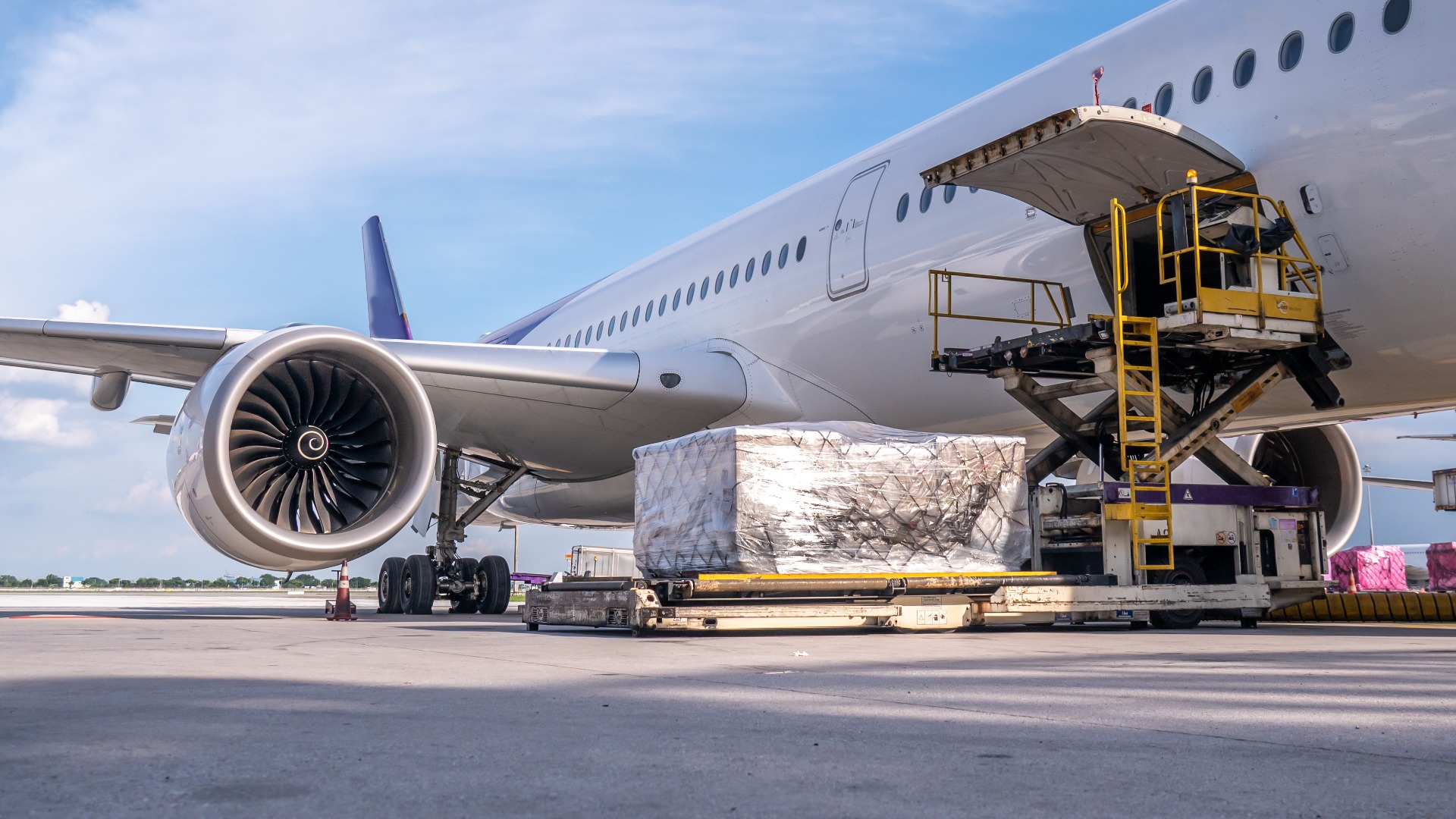 Luftfrachtcontainer werden in ein Flugzeug verladen. Die Luftfrachtsendungen werden am Flughafen für die Verladung in moderne Frachtflugzeuge vorbereitet.