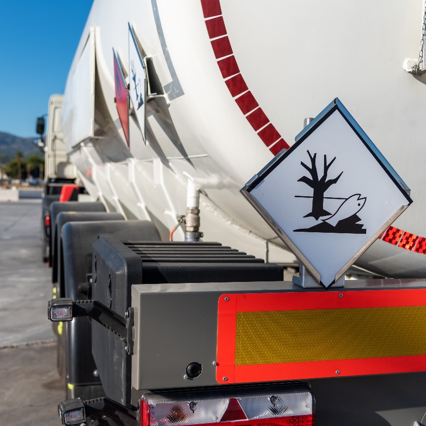Tank truck with dangerous goods, with labels of flammable and pollutant of the environment.